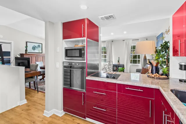 a kitchen with stainless steel appliances kitchen island granite countertop a stove refrigerator and cabinets