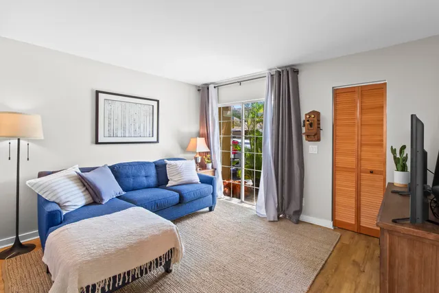 a living room with furniture a flat screen tv and a window