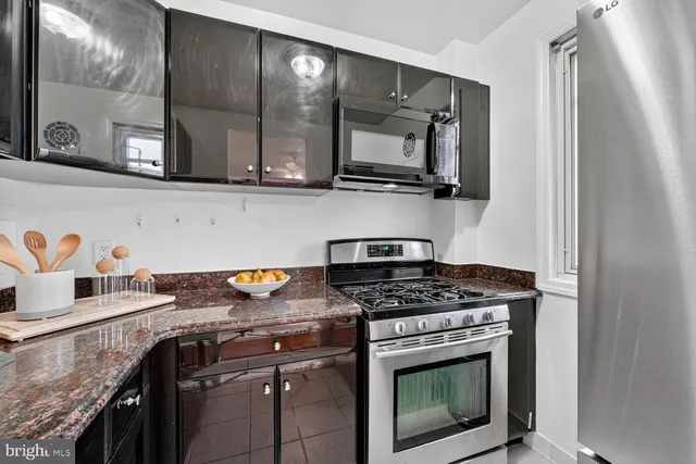 a kitchen with stainless steel appliances granite countertop a stove and a microwave