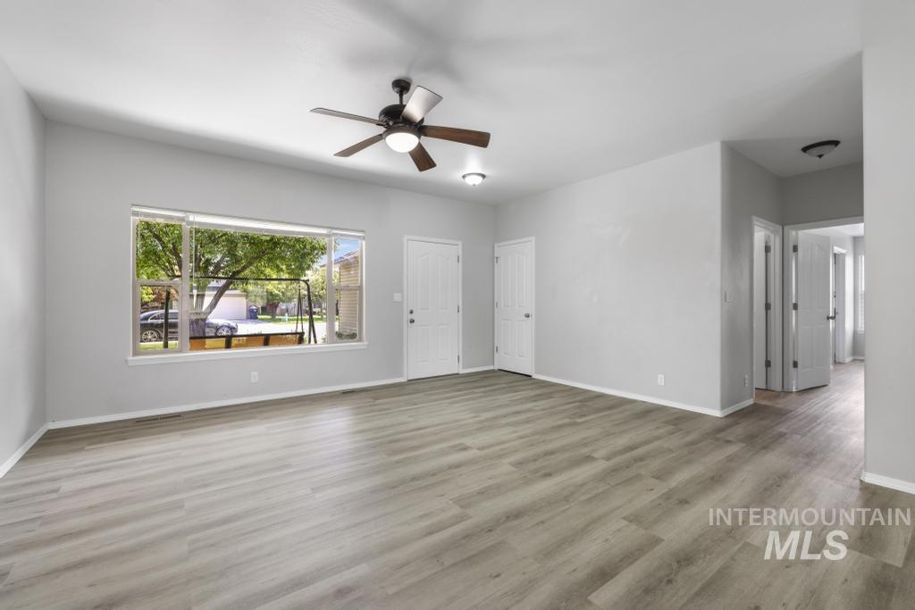 1183 Cortes Loop Twin Falls, ID 83301 - Photo 12 of 30 Spacious interior featuring wood-finish flooring, a large multi-pane window, and a ceiling fan with integrated lighting