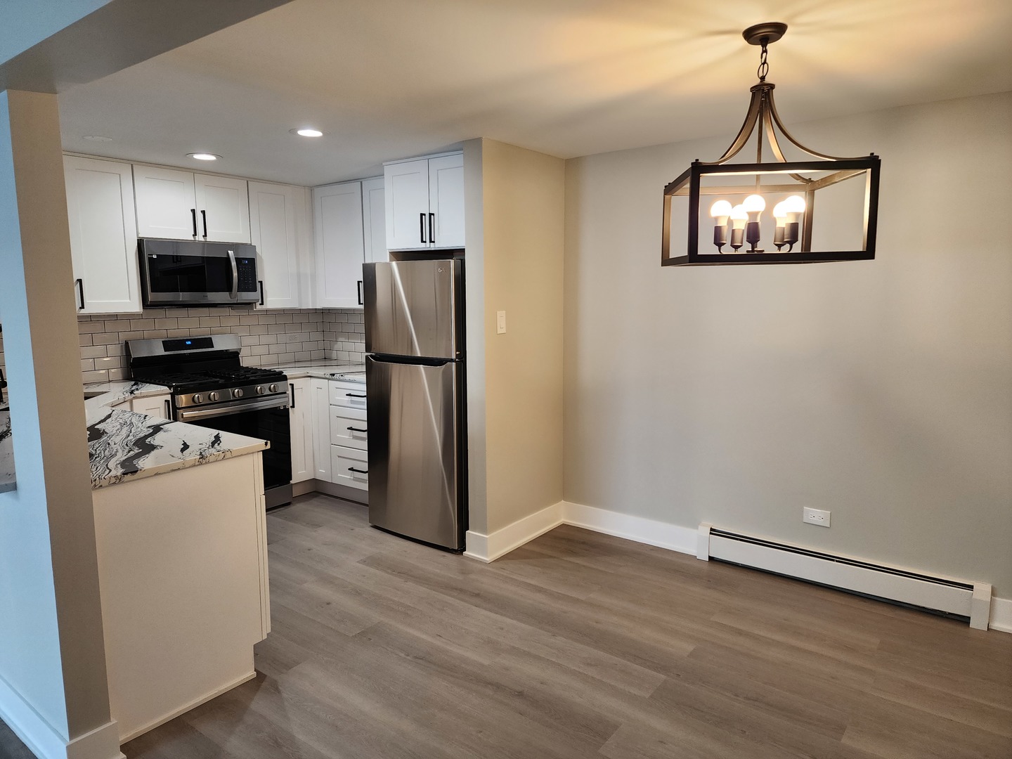 9421 South Roberts Road, Unit 1NW Hickory Hills, IL 60457 - Photo 2 of 12 a kitchen with a refrigerator a stove a microwave and wooden floor