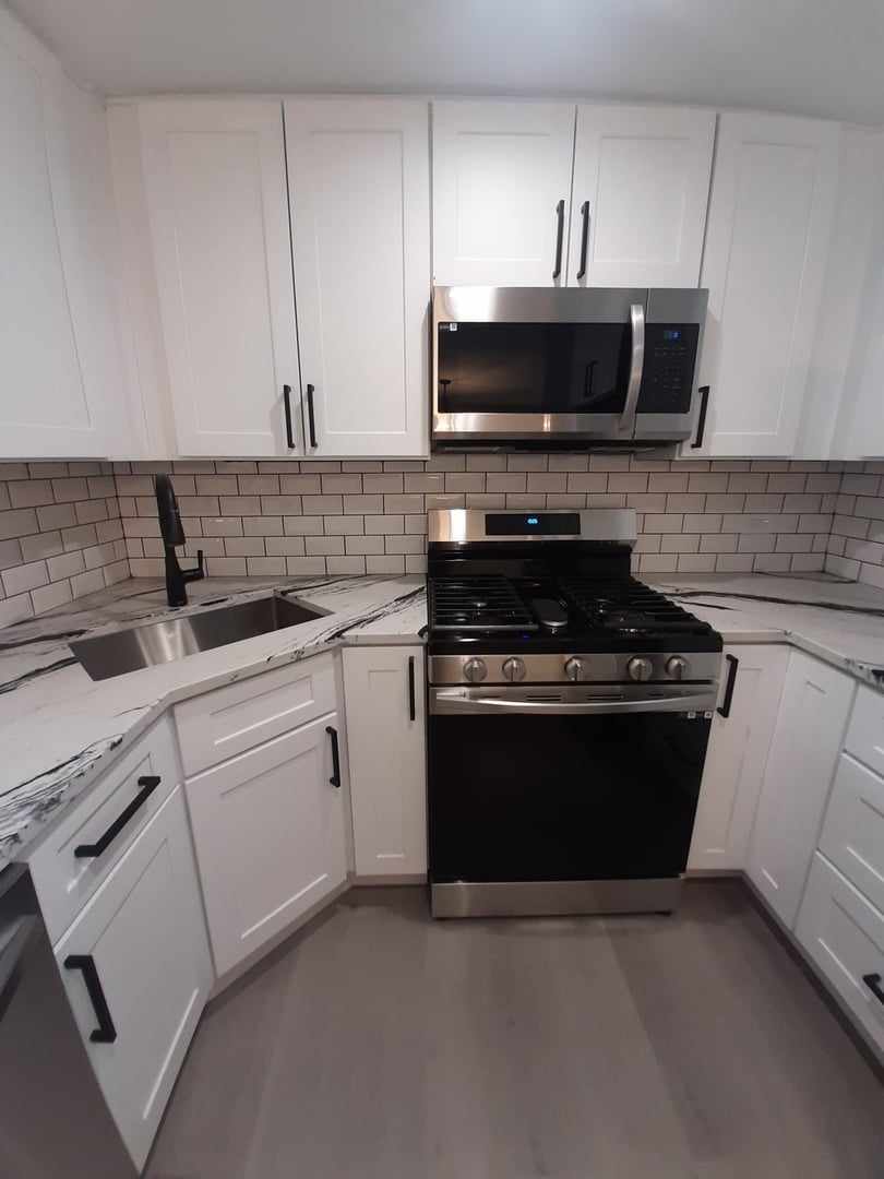9421 South Roberts Road, Unit 1NW Hickory Hills, IL 60457 - Photo 3 of 12 a kitchen with granite countertop white cabinets and stainless steel appliances