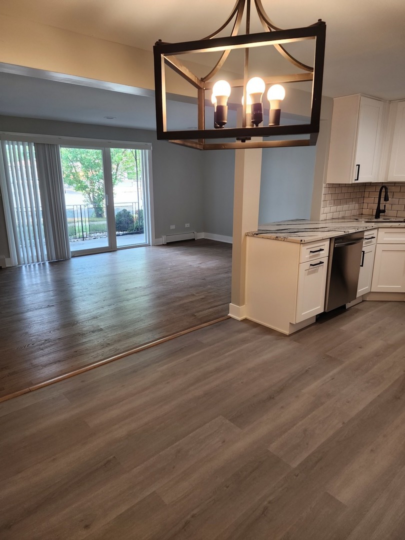 9421 South Roberts Road, Unit 1NW Hickory Hills, IL 60457 - Photo 5 of 12 an empty room with wooden floor and windows