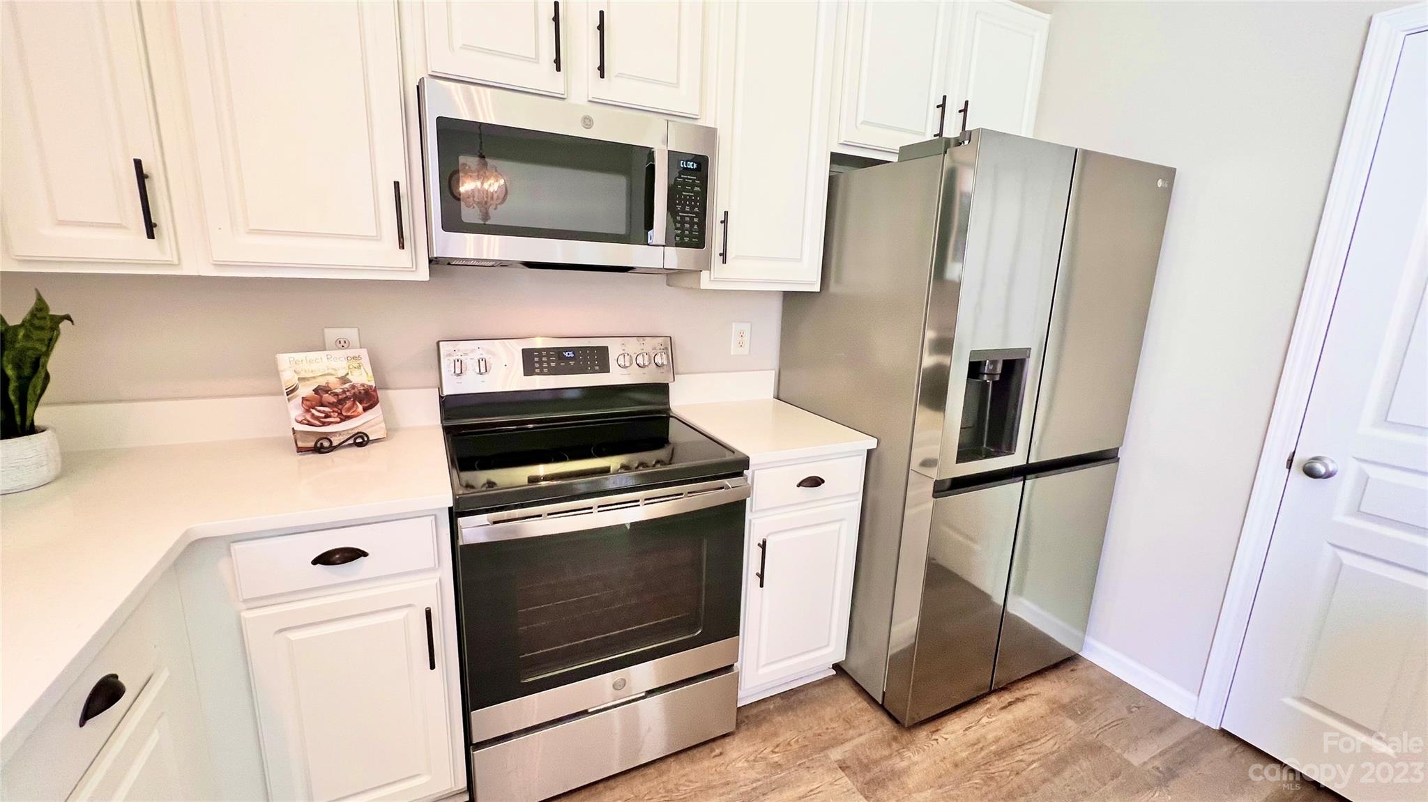 637 Brickdust Court Fort Mill, SC 29708 - Photo 6 of 18 a kitchen with stainless steel appliances white cabinets white stove a refrigerator and a microwave