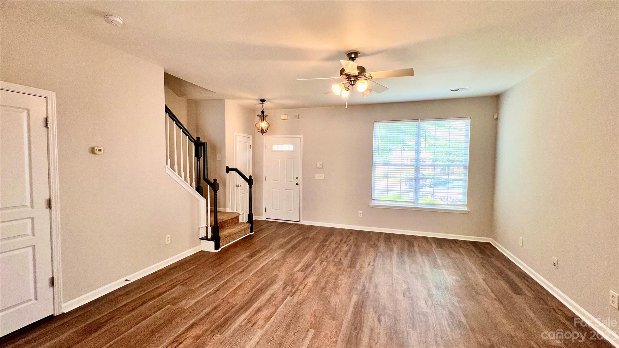 637 Brickdust Court Fort Mill, SC 29708 - Photo 7 of 18 an empty room with wooden floor fan and windows