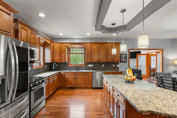 a kitchen with stainless steel appliances granite countertop sink stove top oven and refrigerator