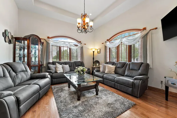 a living room with furniture a flat screen tv and kitchen view
