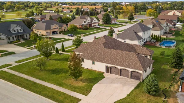 an aerial view of a house with a garden and lake view