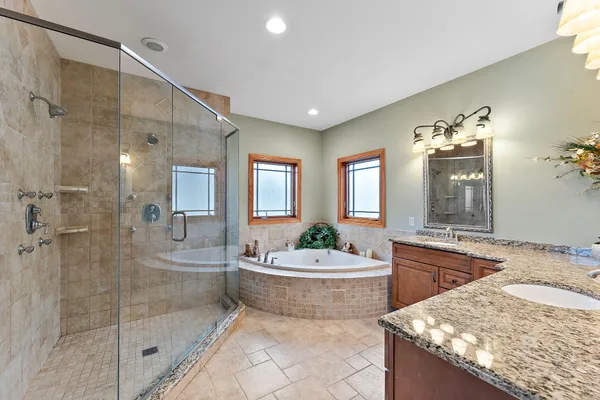 a spacious bathroom with a tub sink shower and mirror