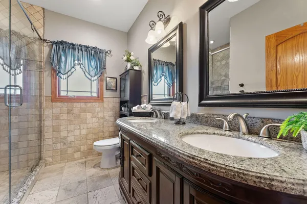 a bathroom with a granite countertop sink a toilet and mirror
