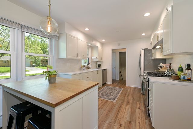 a kitchen with stainless steel appliances granite countertop a sink stove and refrigerator