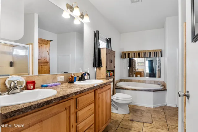 a bathroom with a granite countertop sink mirror vanity and toilet
