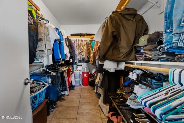 a view of walk in closet with clothes and shoes