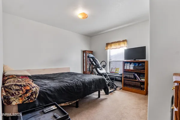 a bedroom with a bed and a flat tv screen on a dresser