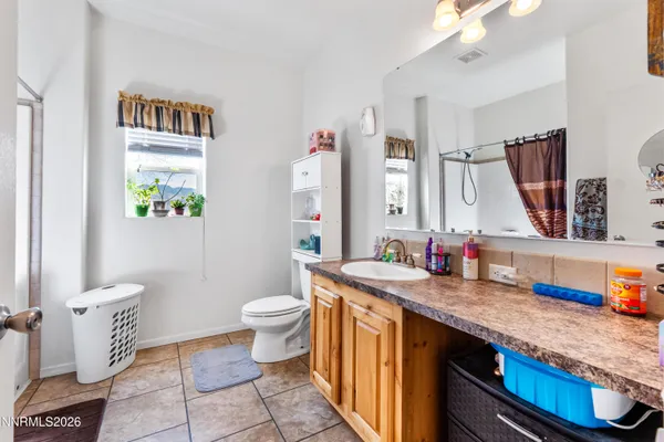 a bathroom with a granite countertop sink mirror vanity and toilet