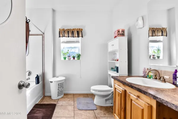 a bathroom with a granite countertop toilet sink and mirror