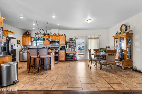 a living room filled with lots of furniture and kitchen view