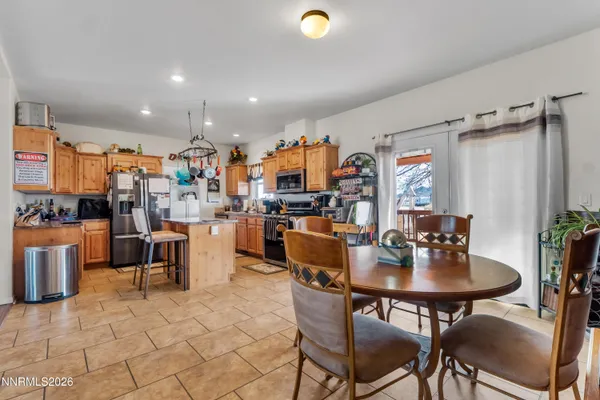 a kitchen with stainless steel appliances granite countertop a table chairs and a refrigerator