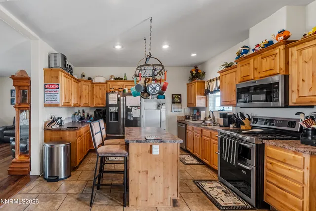 a kitchen with stainless steel appliances kitchen island granite countertop a stove and a sink