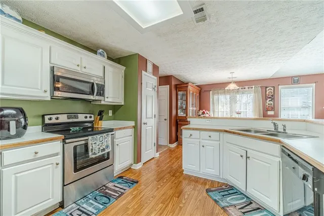 a kitchen with stainless steel appliances granite countertop a stove sink and cabinets