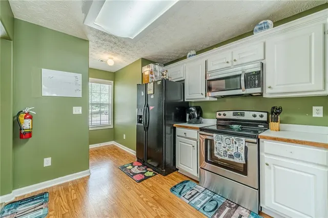 a kitchen with stainless steel appliances granite countertop a refrigerator stove and sink