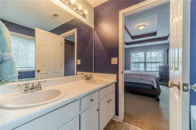 a en suite bathroom with a double vanity sink and a mirror