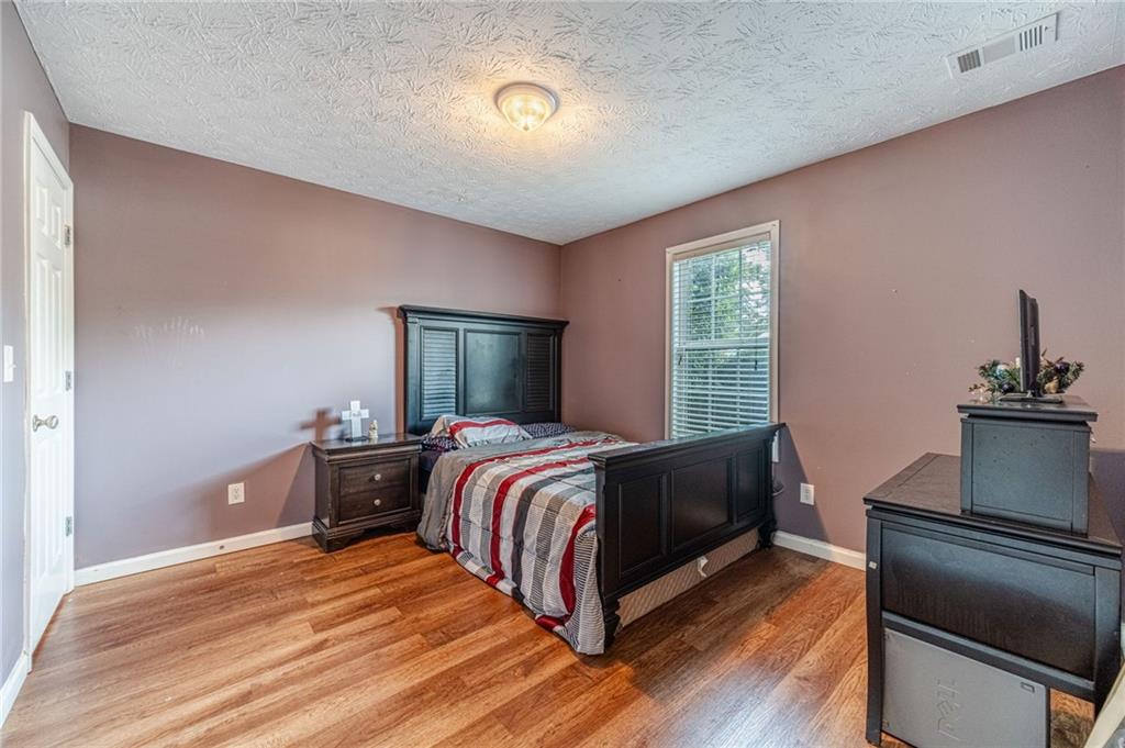 1185 Wendy Way Winder, GA 30680 - Photo 29 of 43 a bedroom with a bed and wooden floor