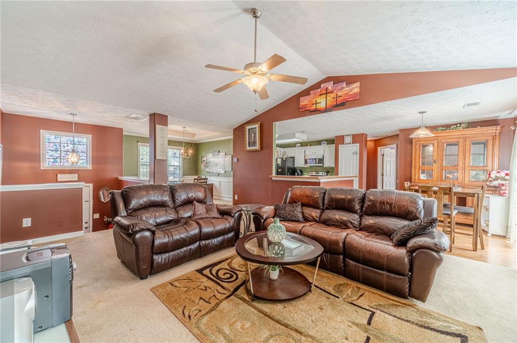 1185 Wendy Way Winder, GA 30680 - Photo 10 of 43 a living room with furniture a chandelier and a dining table