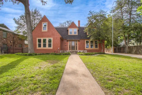 a view of a brick house with a yard