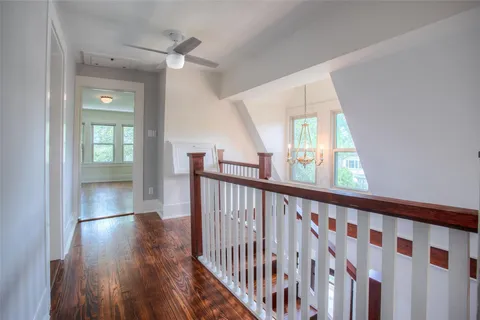 a view of hallway with wooden floor and stairs