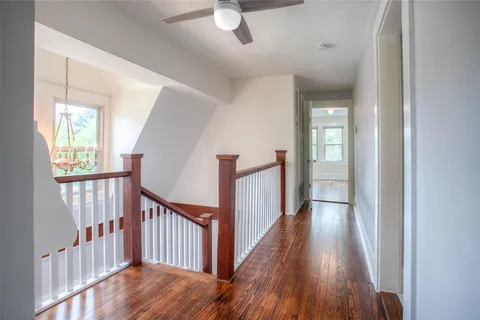 a view of a hallway with wooden floor and windows