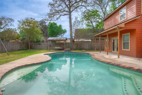 a view of a house with a yard patio and a tree