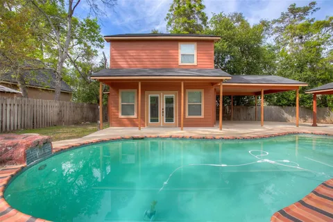 a view of a house with pool and a yard