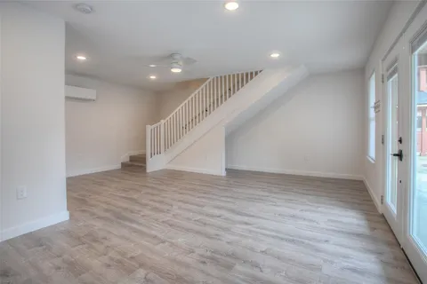 an empty room with wooden floor and staircase