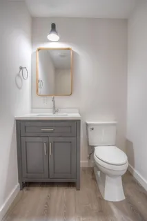 a bathroom with a toilet sink and mirror