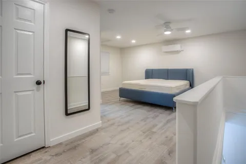 a living room with a bed and a refrigerator