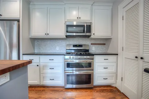 a kitchen with stainless steel appliances granite countertop a stove and a microwave