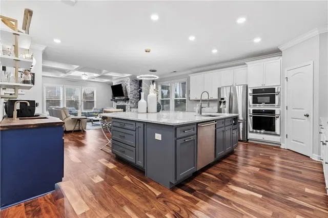 a kitchen with granite countertop white cabinets and stainless steel appliances