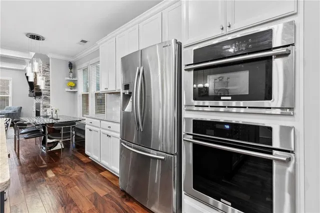 a kitchen with stainless steel appliances granite countertop a sink and a wooden floors