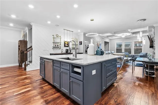 a kitchen with stainless steel appliances kitchen island granite countertop a dining table chairs stove and white cabinets