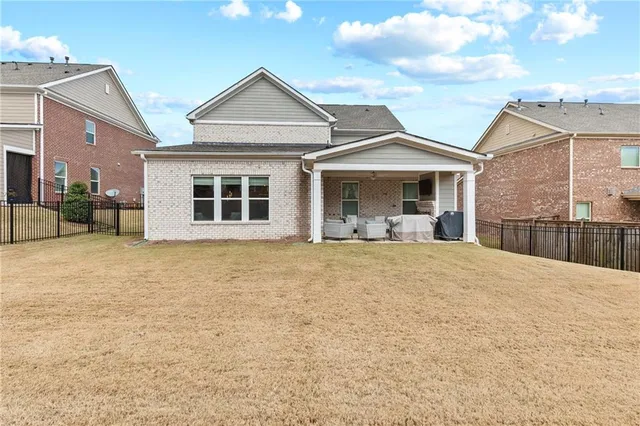 a view of a white house next to a yard with a trees