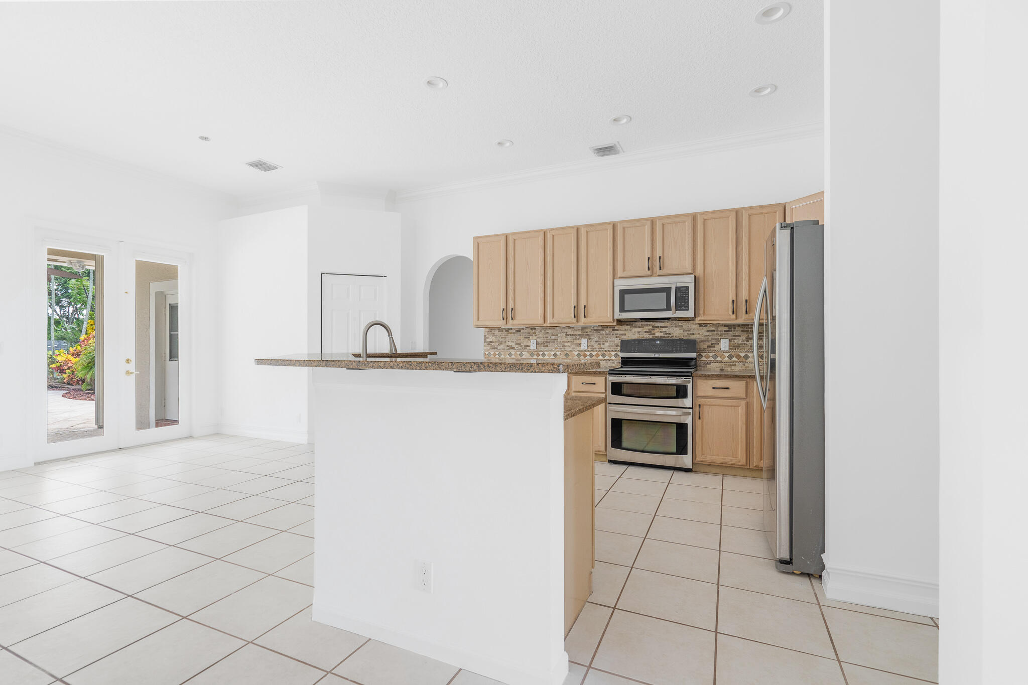 12253 Rockledge Circle Boca Raton, FL 33428 - Photo 17 of 36 a kitchen with granite countertop a refrigerator and a stove top oven