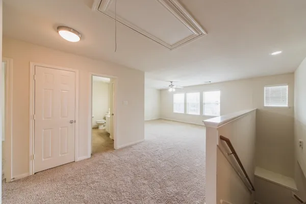 an empty room with a window and a kitchen