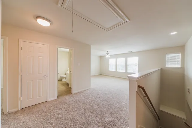 an empty room with a window and a kitchen