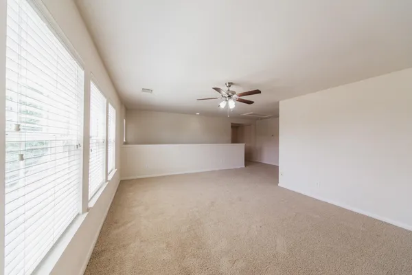 an empty room with a window and a fan