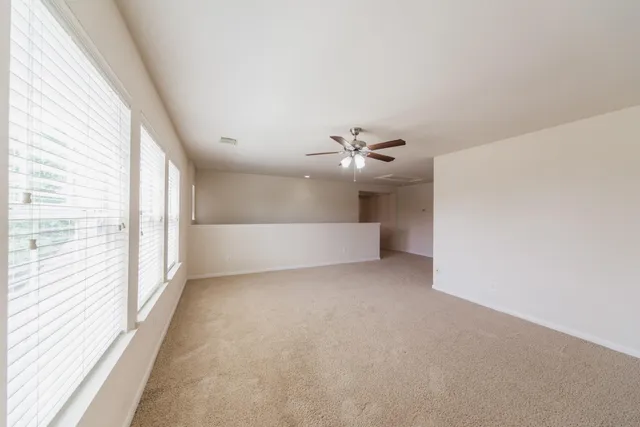 an empty room with a window and a fan