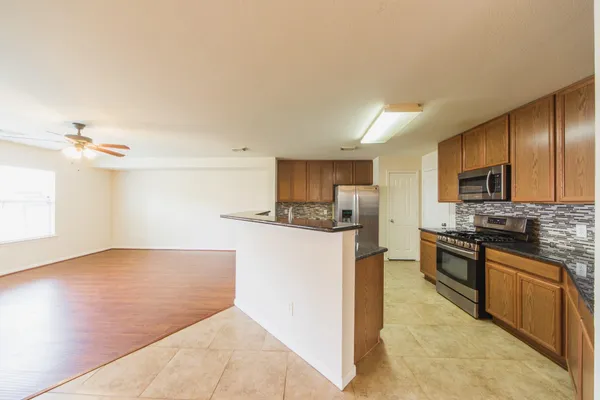 a kitchen with stainless steel appliances granite countertop a sink stove and cabinets