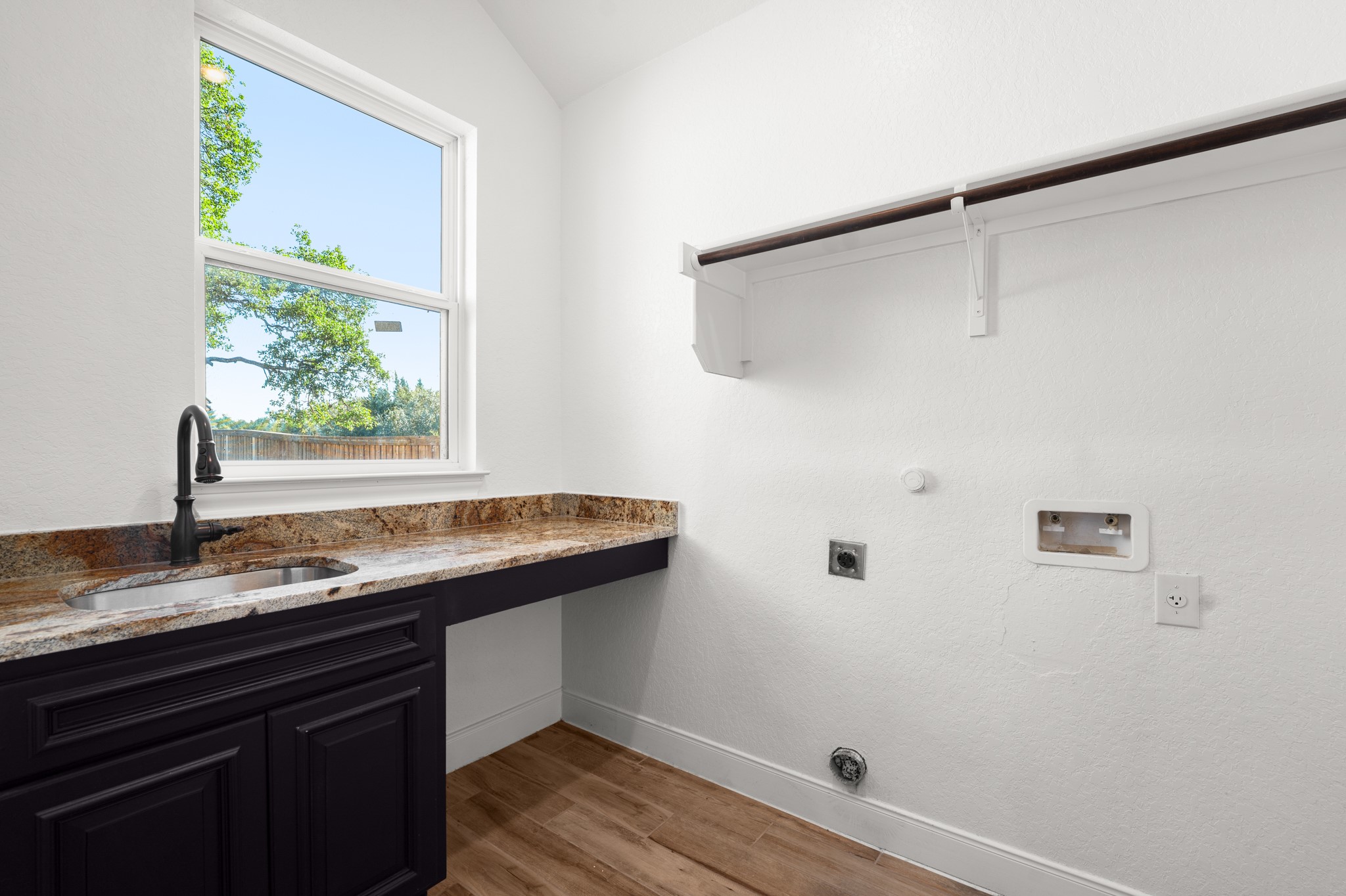 128 Hiram Cook Blanco, TX 78606 - Photo 26 of 40 Laundry room featuring a deep utility sink with a matte black faucet, granite-finish countertop, and ample cabinetry