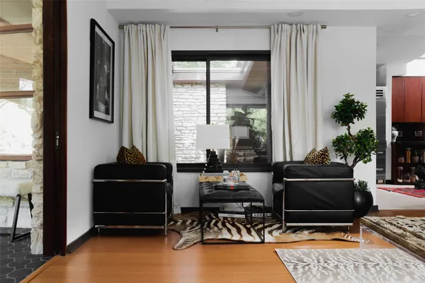 a living room with furniture windows and a potted plant