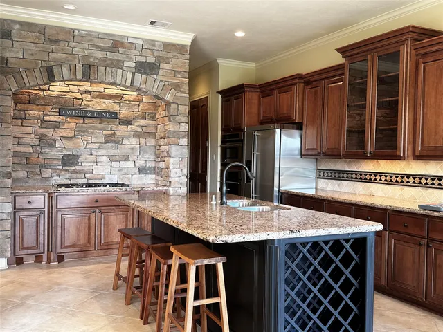 a kitchen with stainless steel appliances kitchen island granite countertop a table chairs in it and wooden floors